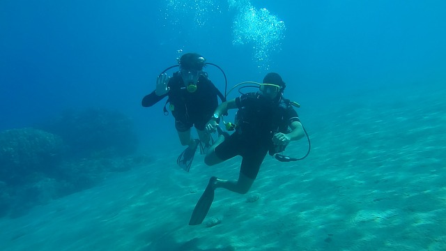 Scuba diver over a colourful coral reef while scuba diving in Bangaram Island