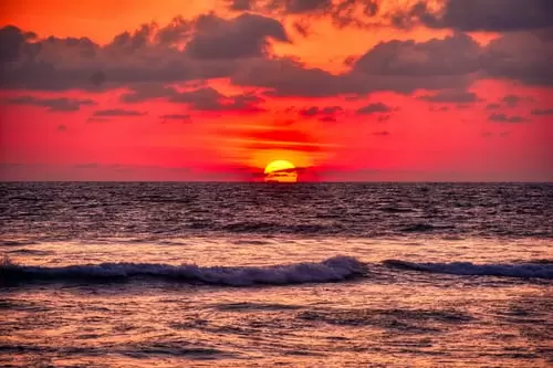 Beautiful sunset view while sun seems like touching sea surface and sky color is a mixture of orange and red color