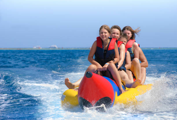 5 people sitting on a banana boat and enjoying the ride in crystal clear waters of Andaman 