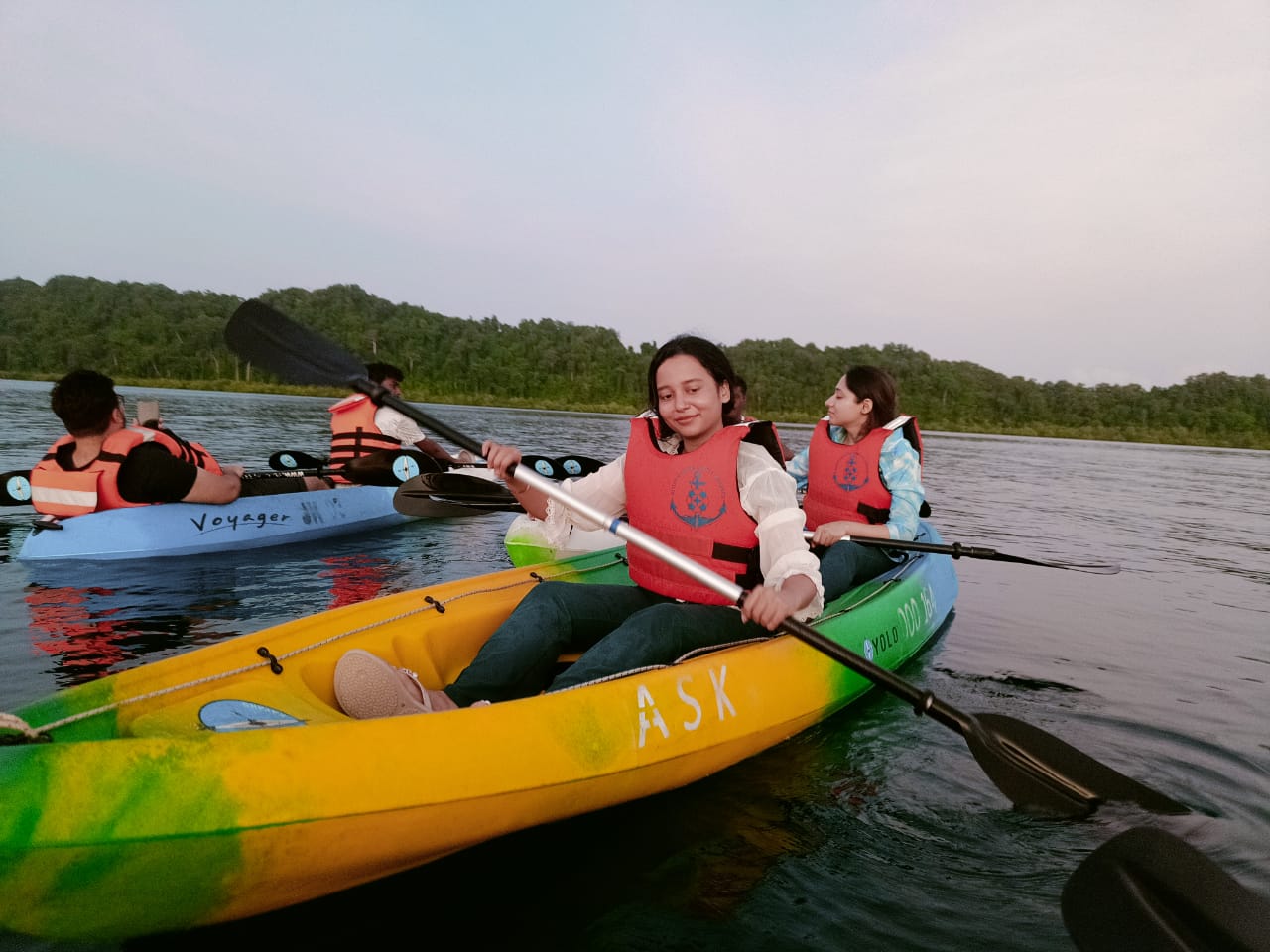 2 male and 2 female guests sitting on 2 kayak and enjoying the kayaking activity in the sea.