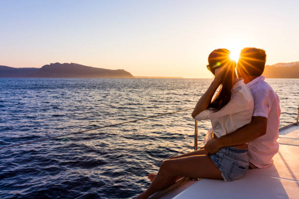 A lovely couple enjoying sunset views while sitting on the boat in Andaman sea. 